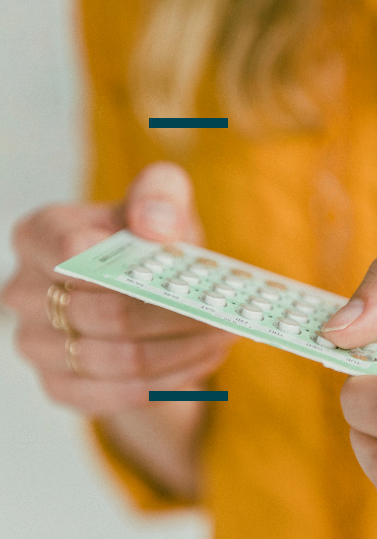 Finger pressing on birth control pill packet