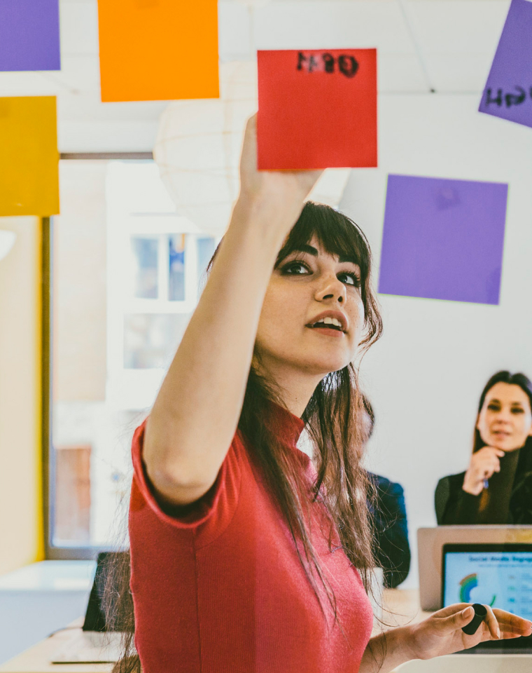 Woman writing on sticky note